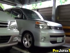 Asian peeing auf dem Parkplatz